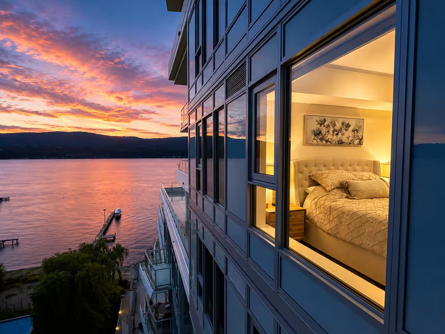 Primary bedroom illuminated at sunset beside Okanagan Lake